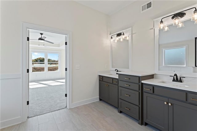7075 NW Magnus Ct, Parkville, MO 64152 - bathroom with ceiling fan, two vanities, and baseboards