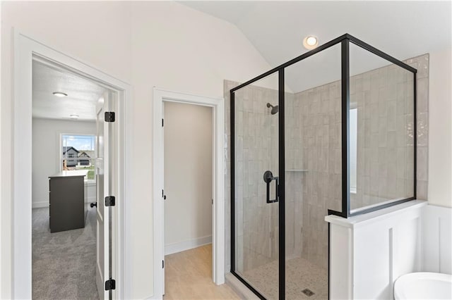 7075 NW Magnus Ct, Parkville, MO 64152 - bathroom featuring a stall shower, vaulted ceiling, a bath, and baseboards