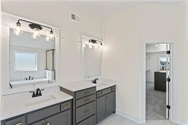 7075 NW Magnus Ct, Parkville, MO 64152 - bathroom with healthy amount of natural light, vanity, a bath, and baseboards