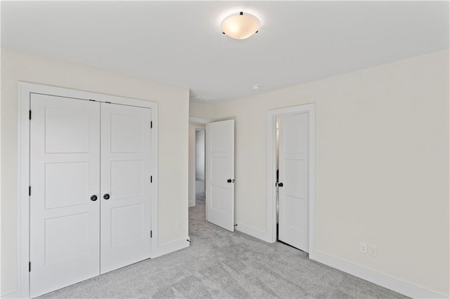 unfurnished bedroom featuring light carpet and a closet