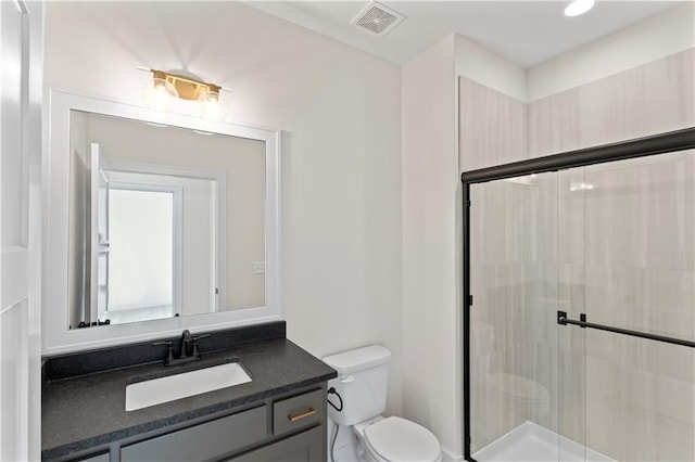 bathroom featuring vanity, toilet, and an enclosed shower