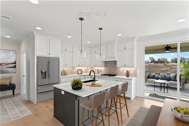7075 NW Magnus Ct, Parkville, MO 64152 - kitchen with stainless steel refrigerator with ice dispenser, a sink, gas stovetop, light countertops, and white cabinets