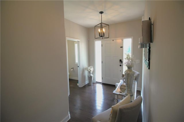 foyer entrance featuring dark hardwood / wood-style floors and a chandelier