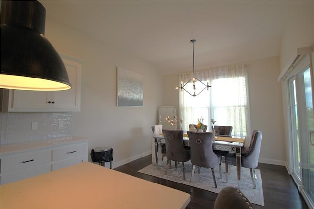 dining space featuring dark wood-type flooring and an inviting chandelier