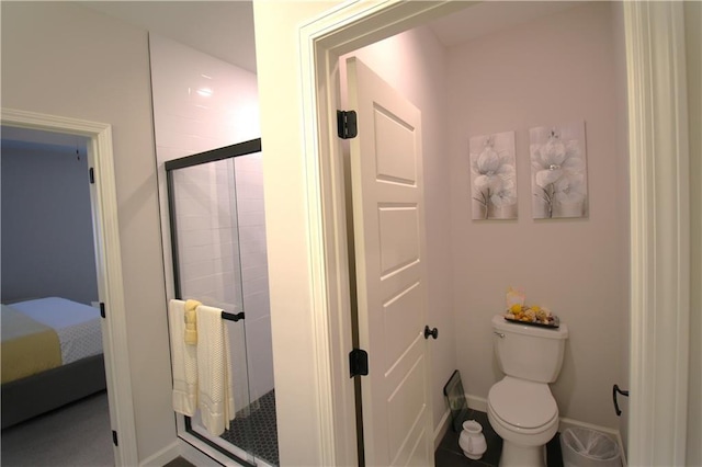 bathroom with toilet and a shower with door