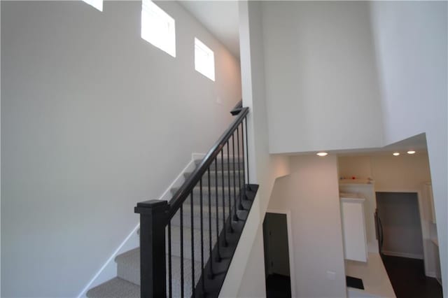 staircase featuring a towering ceiling