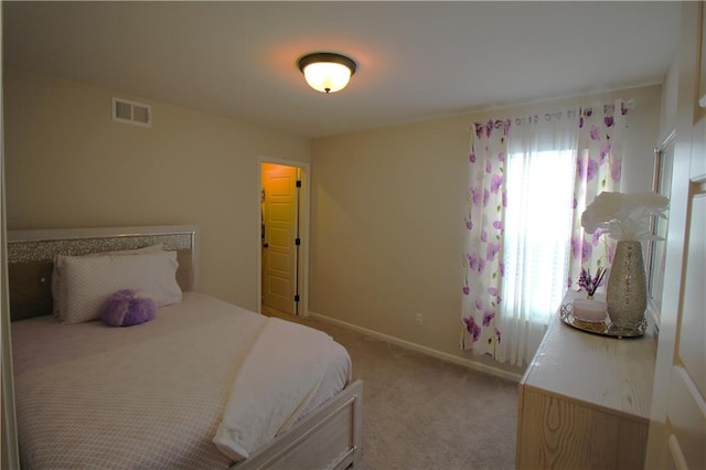 bedroom featuring light carpet and multiple windows