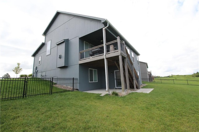 rear view of house featuring a lawn, a patio, and a balcony