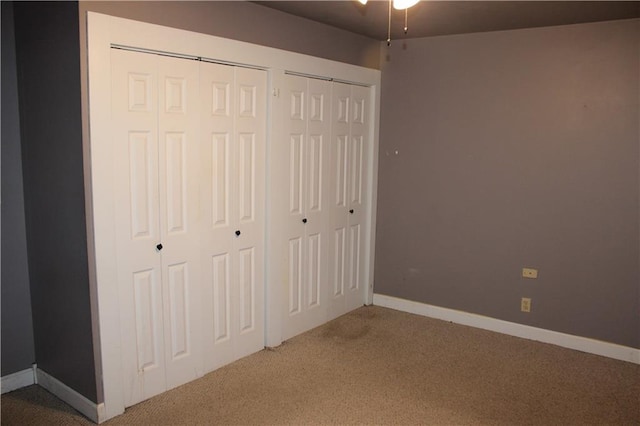 unfurnished bedroom featuring carpet floors and two closets