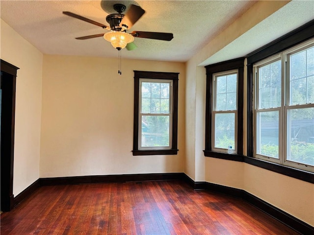 unfurnished room featuring a textured ceiling, ceiling fan, and dark hardwood / wood-style floors