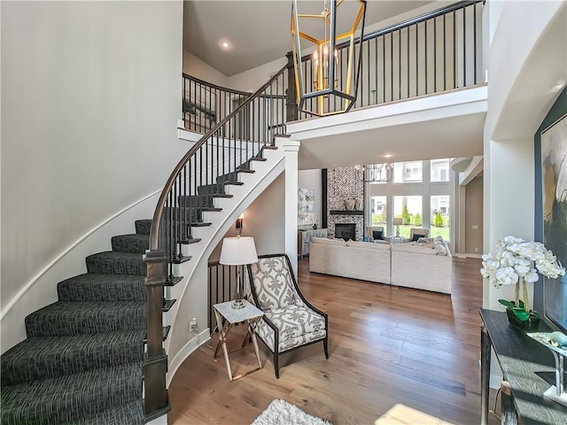 17212 Nieman Rd, Overland Park, KS 66221 - staircase featuring a towering ceiling, wood finished floors, a stone fireplace, and baseboards