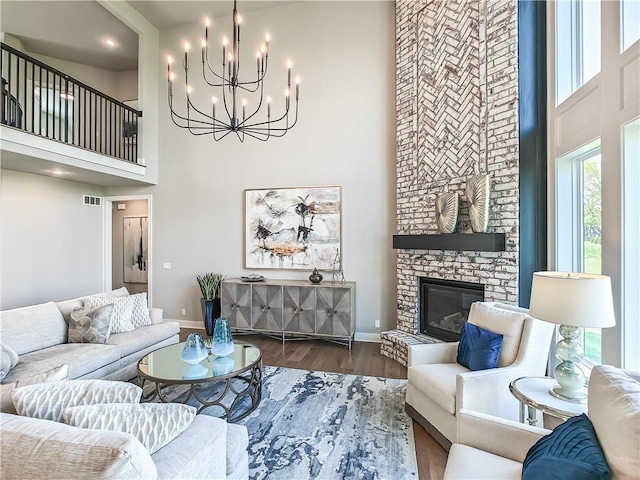 17212 Nieman Rd, Overland Park, KS 66221 - living area featuring a towering ceiling, baseboards, a stone fireplace, wood finished floors, and a chandelier