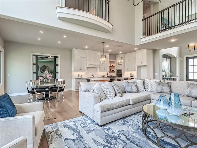 17212 Nieman Rd, Overland Park, KS 66221 - living room with light wood-type flooring, recessed lighting, arched walkways, a chandelier, and baseboards