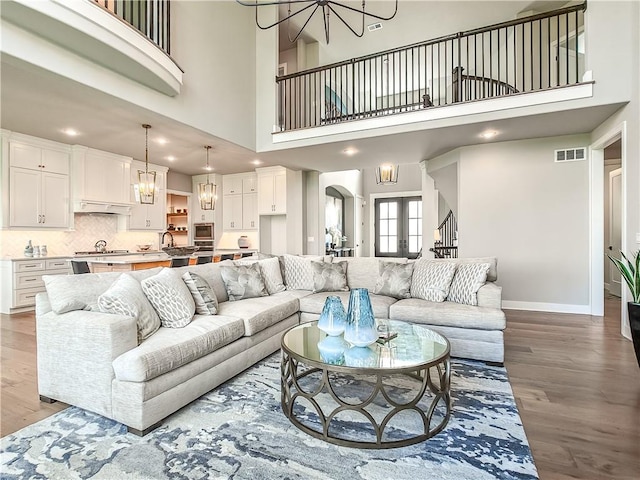 17212 Nieman Rd, Overland Park, KS 66221 - living room featuring a chandelier, wood finished floors, baseboards, arched walkways, and recessed lighting