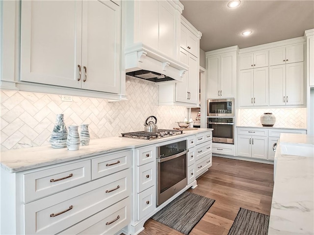 17212 Nieman Rd, Overland Park, KS 66221 - kitchen featuring appliances with stainless steel finishes, premium range hood, decorative backsplash, white cabinets, and recessed lighting