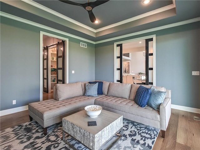 17212 Nieman Rd, Overland Park, KS 66221 - living room featuring ornamental molding, a raised ceiling, wood finished floors, a ceiling fan, and baseboards