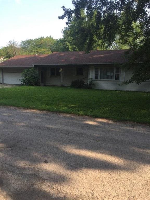 ranch-style house with a garage and a front yard