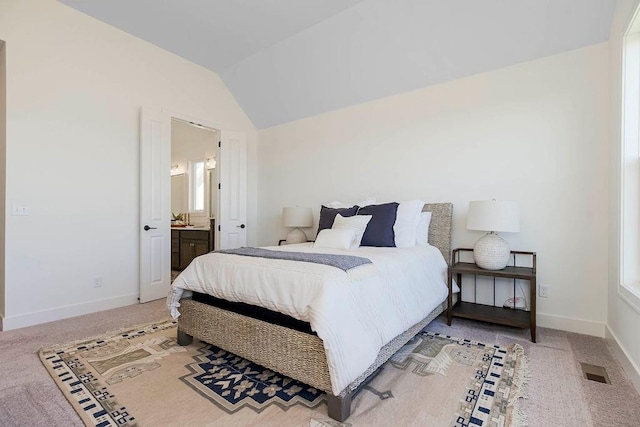 carpeted bedroom featuring connected bathroom and vaulted ceiling