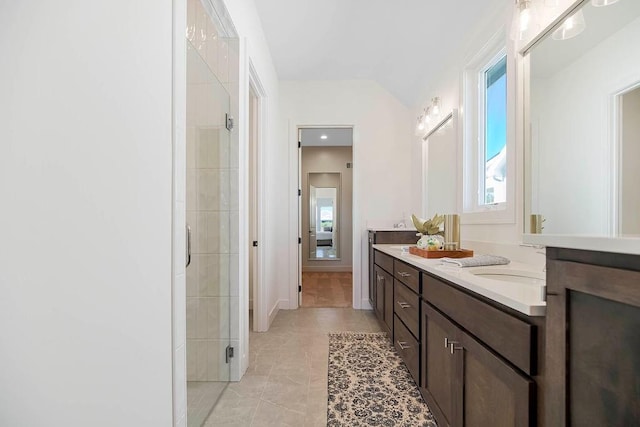 bathroom with vanity, lofted ceiling, tile patterned floors, and walk in shower