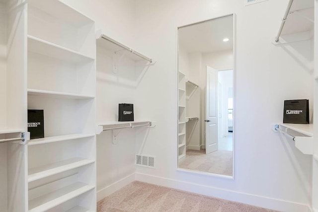 walk in closet featuring light colored carpet