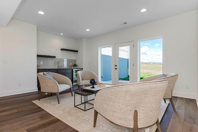 living area with sink, beverage cooler, dark hardwood / wood-style floors, and french doors