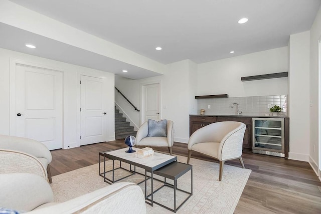 living room with wine cooler, hardwood / wood-style flooring, and wet bar