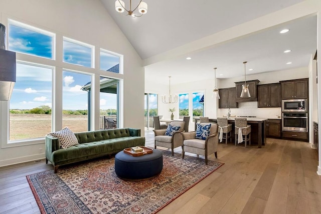 living room featuring light hardwood / wood-style flooring, a wealth of natural light, and a chandelier