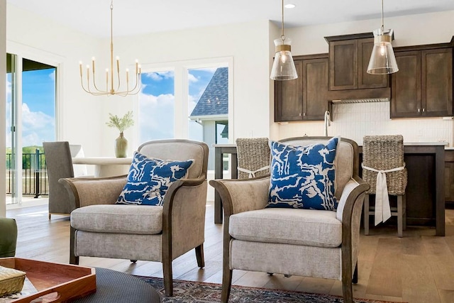 sitting room with a chandelier and light wood-type flooring