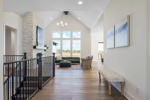 hallway with hardwood / wood-style floors, beam ceiling, a notable chandelier, and high vaulted ceiling