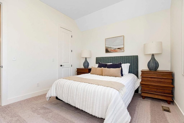 carpeted bedroom with lofted ceiling