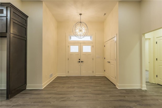 foyer entrance featuring dark wood-type flooring and an inviting chandelier