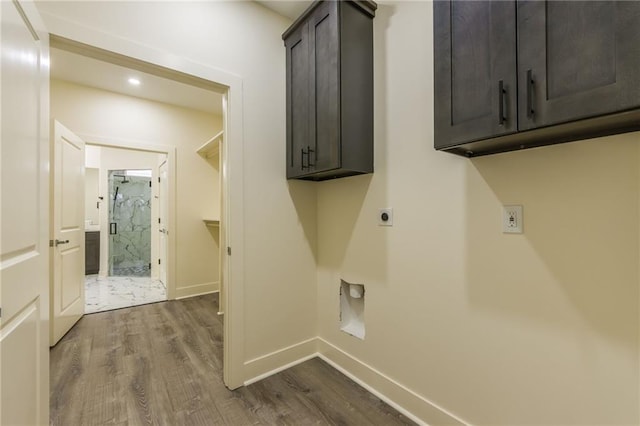 laundry room with cabinets, wood-type flooring, and hookup for an electric dryer