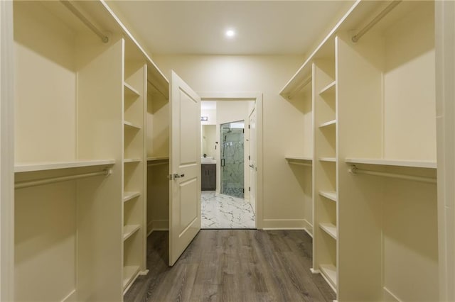 walk in closet with dark wood-type flooring