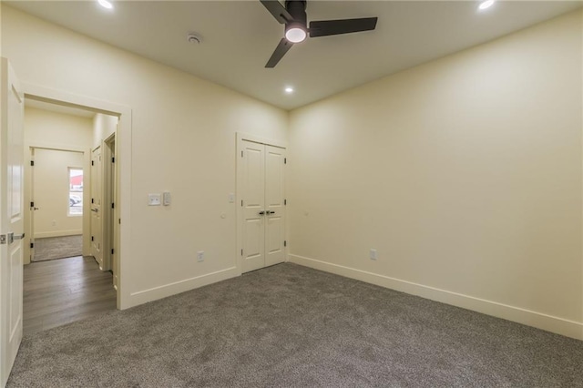 spare room with dark colored carpet and ceiling fan