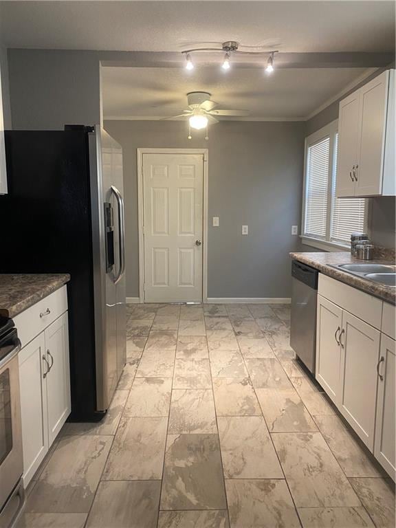 kitchen with stainless steel appliances, light tile patterned floors, ceiling fan, white cabinetry, and rail lighting