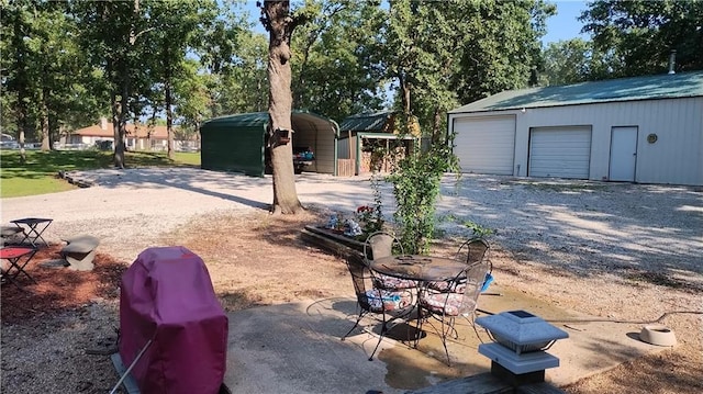 view of yard with a carport, an outbuilding, and a garage