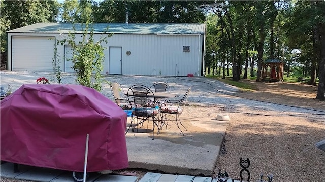 view of patio with an outbuilding, a grill, and a garage