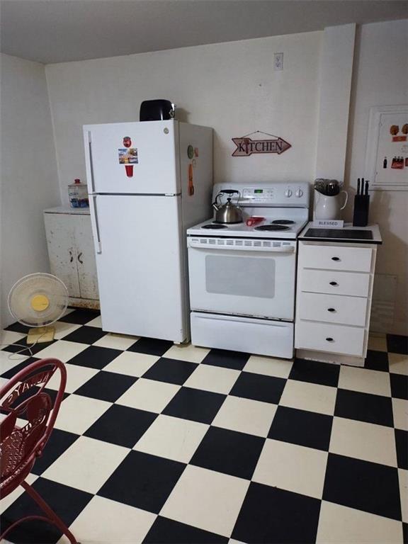 kitchen with white cabinets, light tile patterned floors, and white appliances