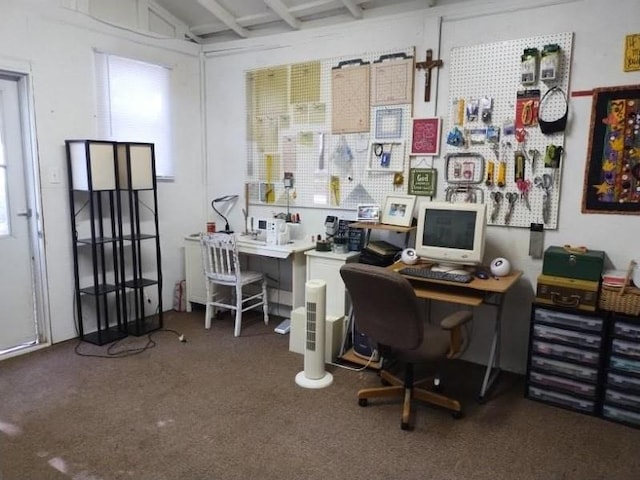 office with a healthy amount of sunlight, a workshop area, and dark colored carpet