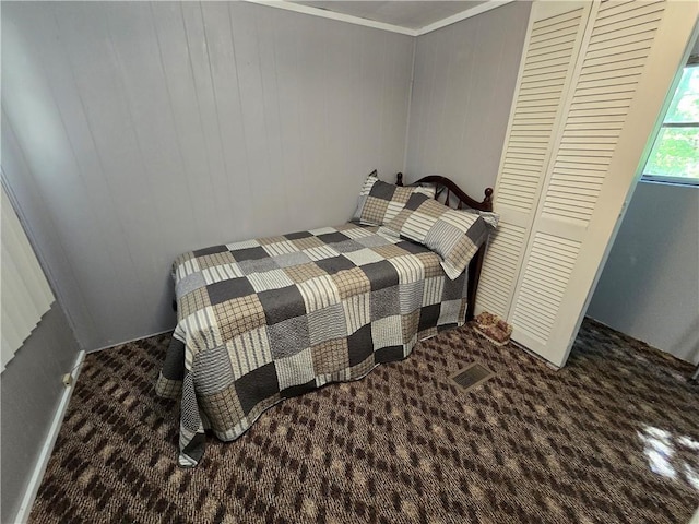 bedroom with crown molding and dark carpet