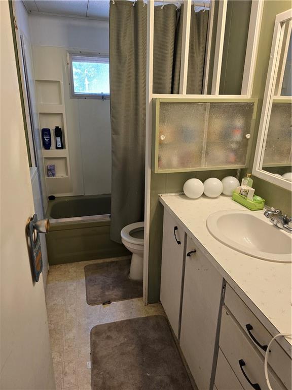 full bathroom featuring vanity, shower / bath combination with curtain, and toilet