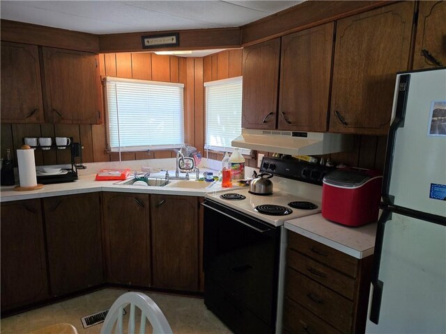 kitchen featuring electric range, light tile patterned floors, fridge, wall chimney exhaust hood, and sink