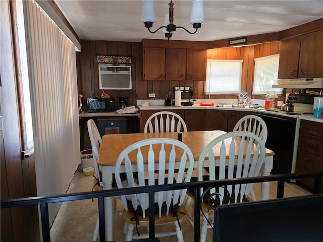 kitchen featuring wooden walls, a chandelier, ventilation hood, range with electric cooktop, and sink