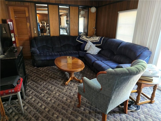 carpeted living room with wood walls