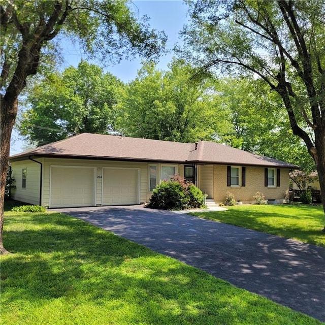 ranch-style house with driveway, a front lawn, an attached garage, and brick siding