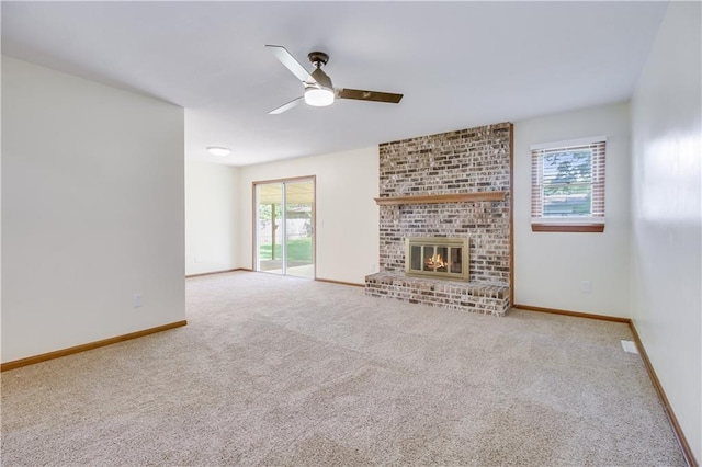 unfurnished living room with a ceiling fan, light carpet, a fireplace, and baseboards