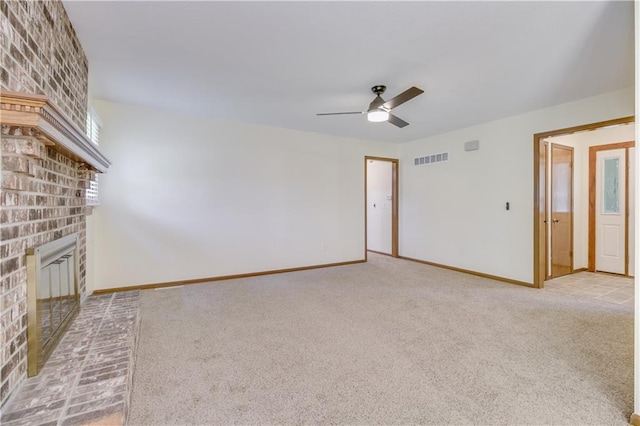 unfurnished living room featuring light colored carpet, visible vents, a fireplace, and baseboards