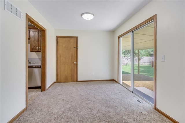 empty room with visible vents, light carpet, and baseboards