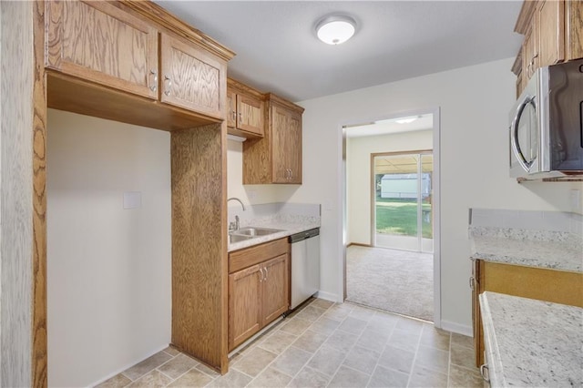 kitchen featuring appliances with stainless steel finishes, light countertops, and a sink