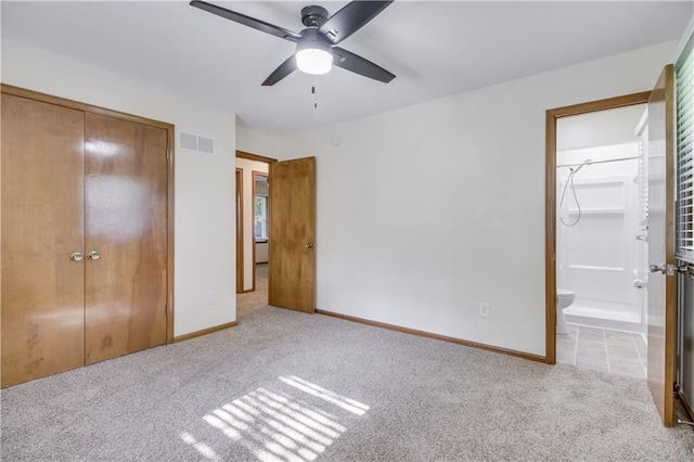 unfurnished bedroom featuring light carpet, baseboards, visible vents, ensuite bath, and a closet